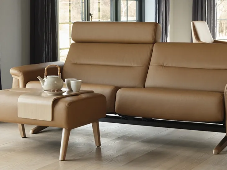 Divano lineare relax rivestito in pelle con poggiatesta reclinabili e struttura in legno Stella Wood di Stressless